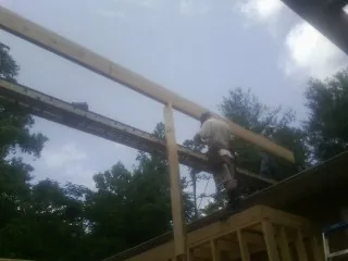 Carpenter setting a ridge beam over a new addition frame — Ice Dam Removal by Roofing Brothers in Orrstown