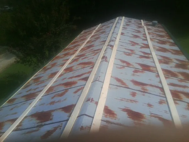 Rusted metal roof panels with new wood purlins before replacement — Storm Damage Roof Repair in Orrstown by Roofing Brothers