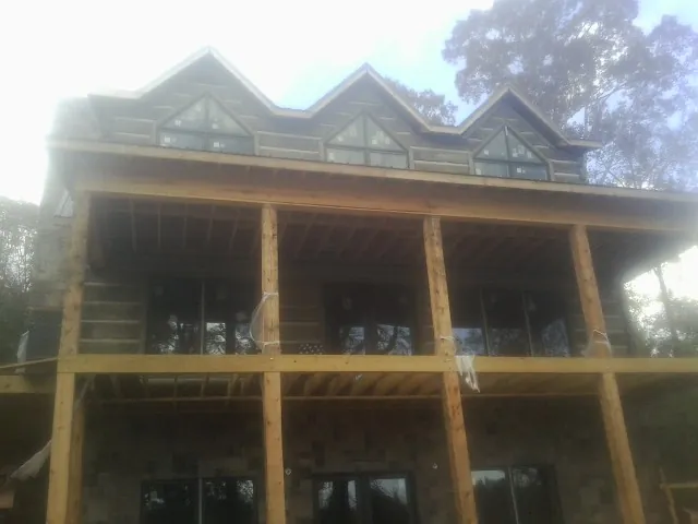 Dormers and porch framing on a large log home under construction — Roof Coating work by our crew in Orrstown