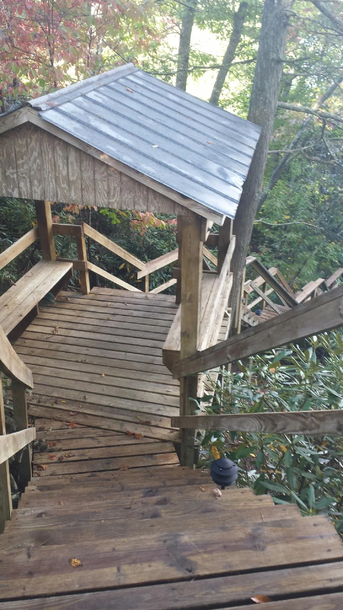 Metal roofed shelter over wooden steps on a wooded walkway — Skylight Repair & Installation work by our crew in Orrstown